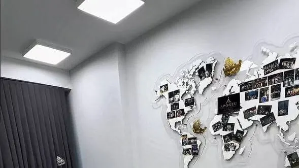 Sala studioului: cortina gri, lumina de sus și harta cu fotografii de pe perete.